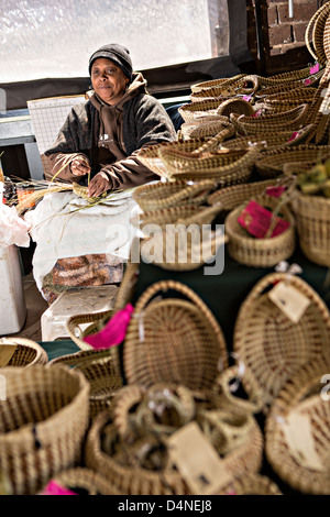 Gullah woman weaving sweetgrass baskets at the Historic Charleston City Market on Market Street in Charleston, SC. Stock Photo