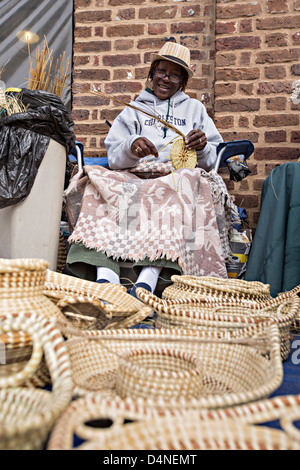 Gullah woman weaving sweetgrass baskets at the Historic Charleston City Market on Market Street in Charleston, SC. Stock Photo