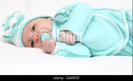 Infant with pacifier looks at the camera Stock Photo