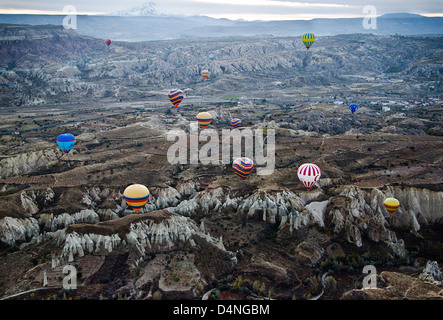 Multitude of colorful hot air balloons taking flight at sunrise in Cappadocia, Turkey Stock Photo
