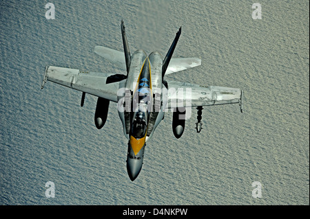 A US Navy F/A-18 Hornet fighter aircraft flies over the Pacific Ocean July 8, 2010 during refueling operations. Stock Photo