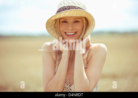 A young woman standing in a wheat field in summertime Stock Photo