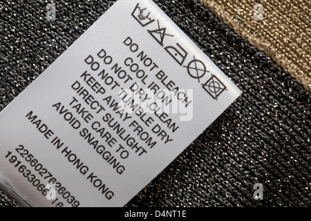 label showing washing instructions in top made in Hong Kong - sold in the UK United Kingdom, Great Britain - care washing symbols and instructions Stock Photo