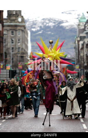 The Parade moves its way up Chichester Street in Belfast during the St Patrick's day celebrations, with snow on the hills behind Stock Photo