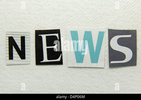 word news cut from newspaper on handmade paper background Stock Photo