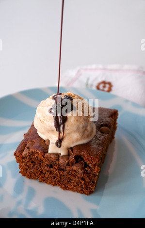 Chocolate cake with vanilla ice cream and chocolate syrup. Close view. Stock Photo