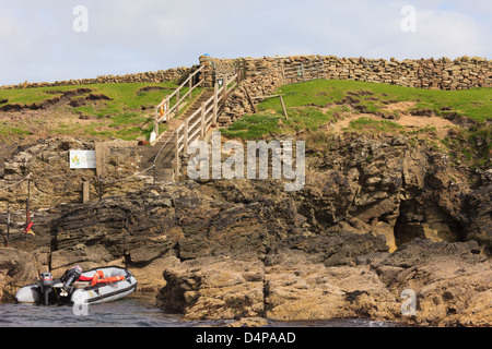 Dinghy by boat landing and steps at entrance for Isle of Noss National Nature Reserve, Shetland Islands, Scotland, UK, Britain Stock Photo