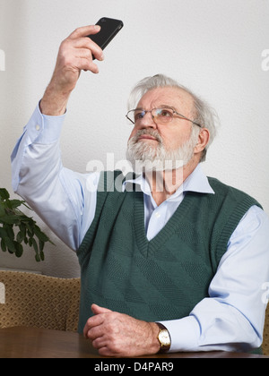 Senior man taking self portrait with smart phone Stock Photo