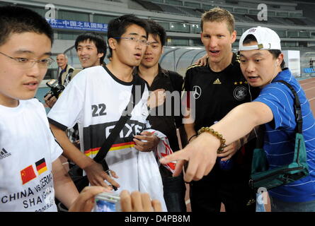 Bastian Schweinsteiger of the German national team (2-R)poses with Chinese soccer fans after a training session in Shanghai, China, 27 May 2009. The German national team is on an Asia tour to play two friendly matches, one in Shanghai and one in Dubai. Photo: Marcus Brandt Stock Photo