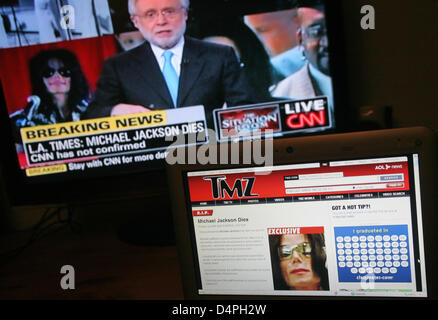 The picture taken in Frankfurt Main, Germany, 26 June 2009, shows the US homepage tmz.com, the first worldwide that announced the death of Michael Jackson, on a computer screen in front of a television screen showing the programme of CNN which informs the public about the topical incidents but can not yet affirm the death of the popstar. tmz.com was considerably faster with breakin Stock Photo