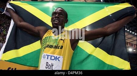 Jamaican Usain Bolt celebrates with a Jamaican flag after winning the men?s 100m final at the 12th IAAF World Championships in Athletics in Berlin, Germany, 16 August 2009. Bolt established a new world record of 9.58 seconds. Photo: KAY NIETFELD Stock Photo