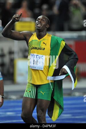 Jamaican Usain Bolt celebrates with a Jamaican flag after winning the men?s 100m final at the 12th IAAF World Championships in Athletics in Berlin, Germany, 16 August 2009. Bolt established a new world record of 9.58 seconds. Photo: BERND THISSEN Stock Photo