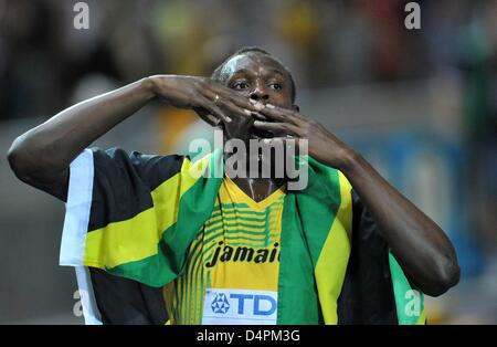 Jamaican Usain Bolt celebrates with a Jamaican flag after winning the men?s 100m final at the 12th IAAF World Championships in Athletics in Berlin, Germany, 16 August 2009. Bolt established a new world record of 9.58 seconds. Photo: BERND THISSEN Stock Photo