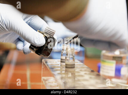 A laboratory assistant puts a test substance into a water sample in the laboratory of the Dow Chemical chemical plant defecator in Stade, Germany, 23 April 2009. Photo: Christian Hager Stock Photo