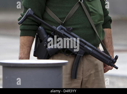 A police officer with machine gun guards the U.S. Embassy to Germany in Berlin, Germany, 25 September 2009. U.S. State Department called US citizens to increase cautiousness and to act low-key when staying in Germany. Increased security measures are continued following a threat video of the terrorist network Al-Qaeda which warned of terrorist attacts if German soldiers are not remo Stock Photo