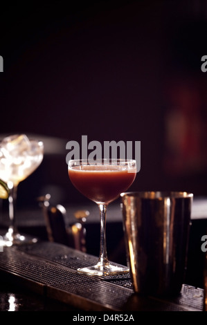 Glass of red wine with shaker on dark background Stock Photo