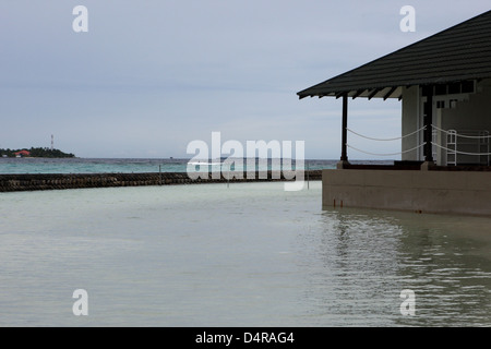 Meedhupparu Island in the Maldives showing flooding over the concrete defense wall possibly due to global warming Stock Photo