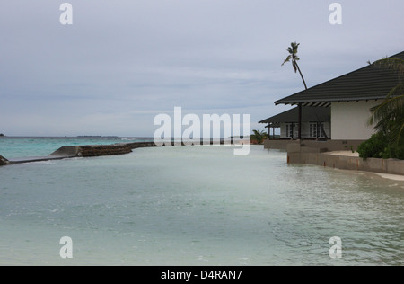 Meedhupparu Island in the Maldives showing flooding over the concrete defense wall possibly due to global warming Stock Photo