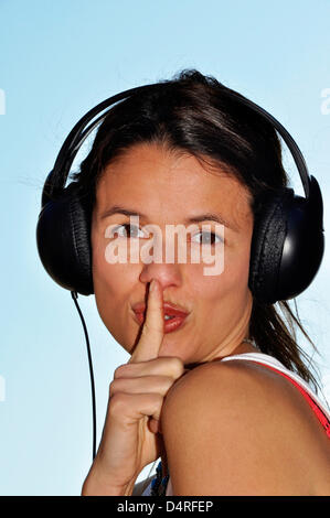 (dpa FILE) - An archive picture, dated 25 September 2011, shows an illustration of a young woman wear a headset while holding a finger to her mouth indicating to be quiet in Berlin, Germany. Fotoarchiv für Zeitgeschichte () Stock Photo