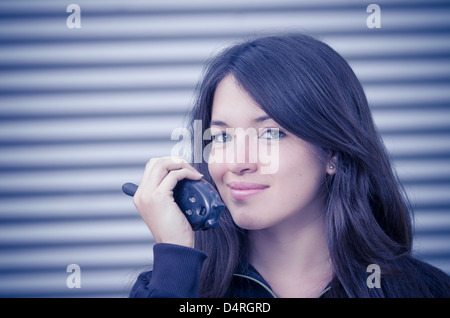 Businesswoman in warehouse using walkie-talkie Stock Photo