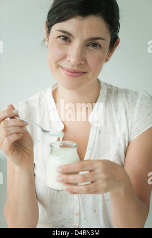 Woman eating yogurt, portrait Stock Photo