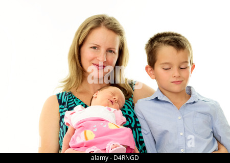 Mother holding her newborn baby while her brother looking at her sister jealously. Stock Photo