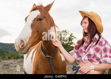 Female teenager petting a horse, Female 19 Caucasian Stock Photo