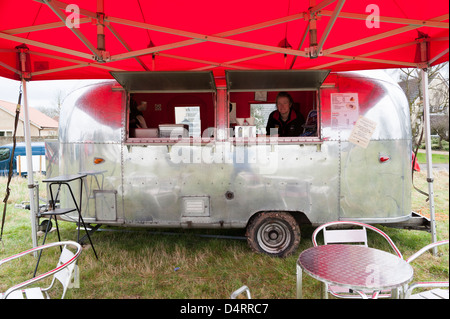 An airstream caravan used as a mobile food stall with a red awning at a country show in the UK Stock Photo