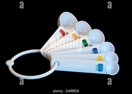 White plastic measuring spoons set isolated on black background Stock Photo