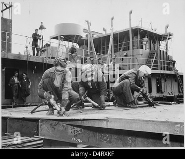 Chippers in a Shipyard [Shipbuilding. Three Women Working], 1942 Stock Photo