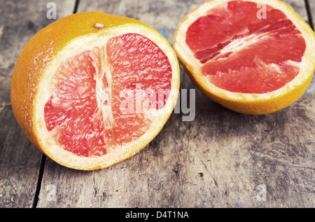 sliced ​​red grapefruit on old table Stock Photo