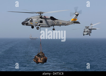 A SH-60J Seahawk transfers cargo during a vertical replenishment. Stock Photo