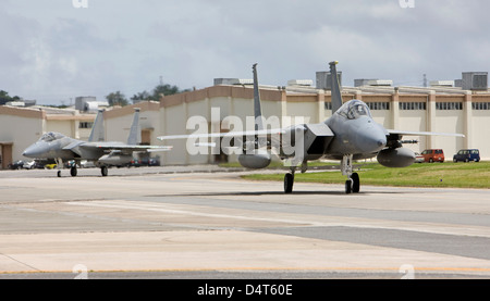 Two F-15's from the 18th Wing at Kadena Air Base, Okinawa taxi to the end of runway to complete thier pre-flight checks. Stock Photo