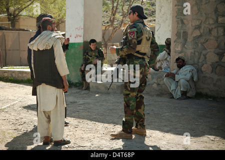 An Afghan National Army Special Forces speaks with Afghan Local Police candidates during a recruitment validation March 16, 2013 in Helmand province, Afghanistan. Stock Photo