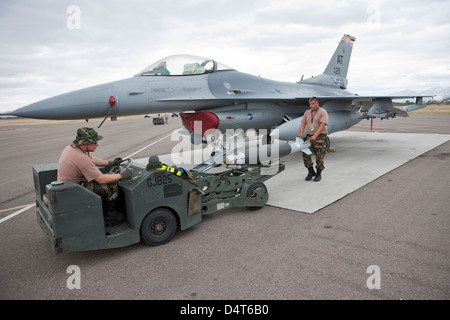 Weapons loaders prepare to load a GBU-38 JDAM on an F-16. Stock Photo