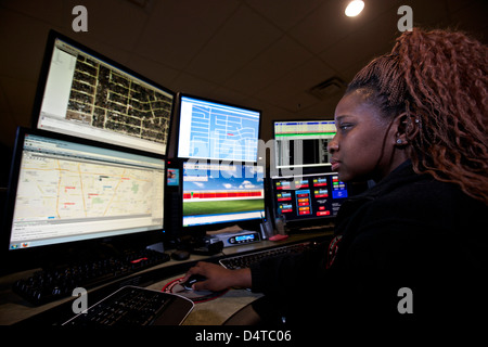 Young woman working in the control room center for emergency service dispatch. Stock Photo