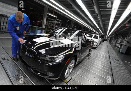 An employee of BMW works on a new 3 series car at the BMW plant in Regensburg, Germany, 22 October 2009. After the extension of the press plant in Regensburg, the car manufacturer plans more investments at the site. About EUR 300 million shall be spent on car body pressing and construction. Photo: Armin Weigel Stock Photo
