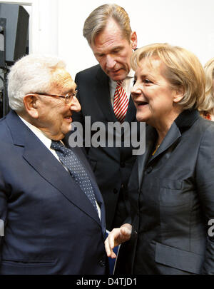 Former US Secretary of State and recipient of the Nobel Peace Prize Henry Kissinger (L) talks German Chancellor Angela Merkel at the German-German museum Villa Schoeningen at Glienicker Bridge between Berlin and Potsdam, Germany, 08 November 2009. Next to them stands Axel Springer Chairman and Chief Executive Mathias Doepfner (C). The museum was opened the night before the Fall of  Stock Photo