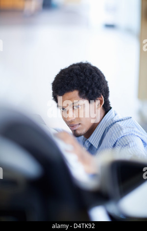 Salesman shining up new car Stock Photo