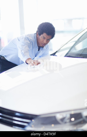 Salesman shining up new car Stock Photo