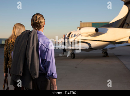 Business people on airplane runway Stock Photo