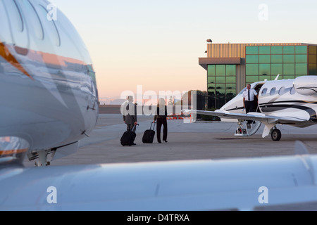 Business people on airplane runway Stock Photo