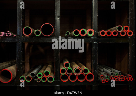 Shelves of colorful metal pipes in plant Stock Photo