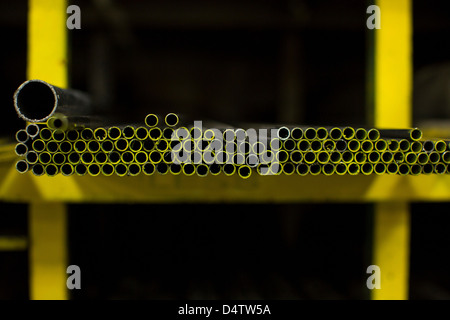 Shelves of colorful metal pipes in plant Stock Photo