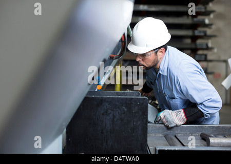 Worker using machinery in metal plant Stock Photo