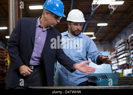 Worker and businessman in metal plant Stock Photo
