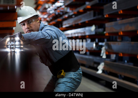 Worker using machinery in metal plant Stock Photo