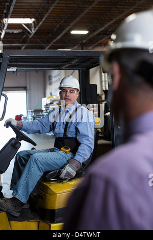 Worker using forklift in metal plant Stock Photo