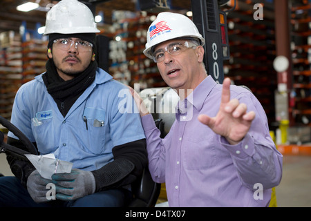 Worker and businessman in metal plant Stock Photo