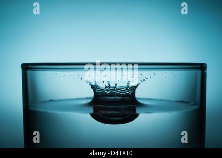 Drop splashing in glass of water Stock Photo